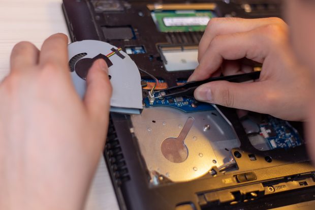 young man hands repare laptop at home