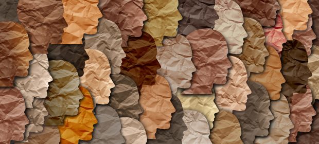 Image of multi-coloured silhouetted ethnic faces rendered in tissue paper. Black history month celebration of diversity and African culture pride as a multi cultural celebration.